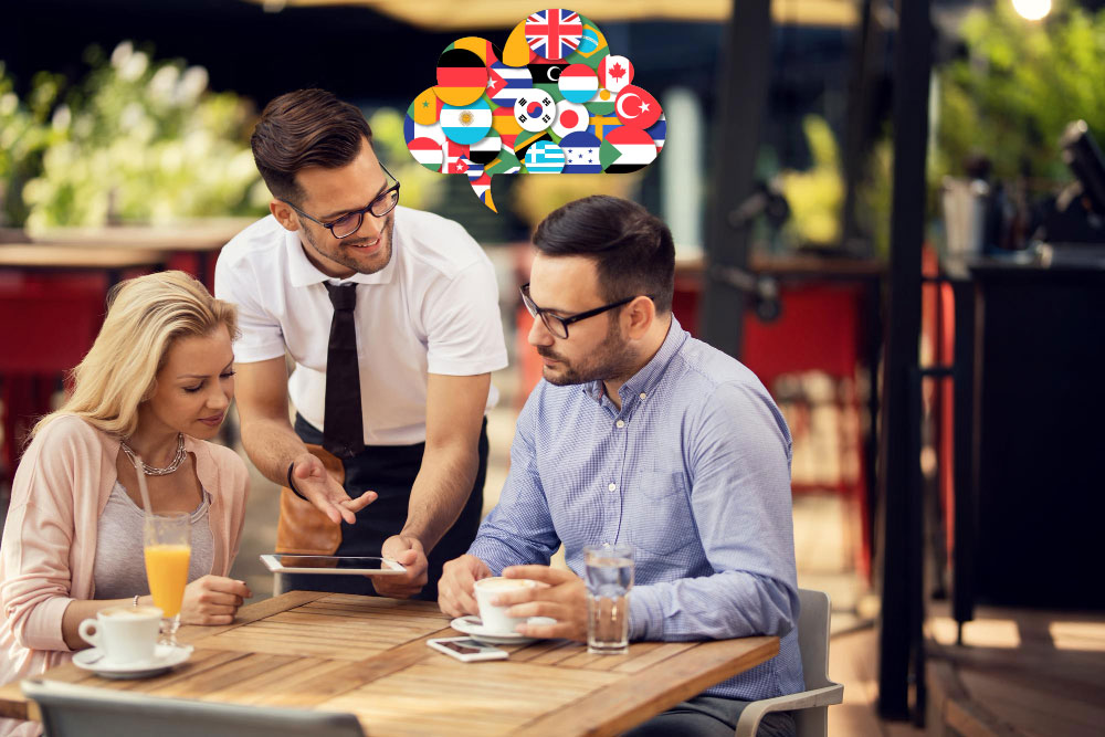 waiter talking to guests while using digital tablet showing them the digital menu